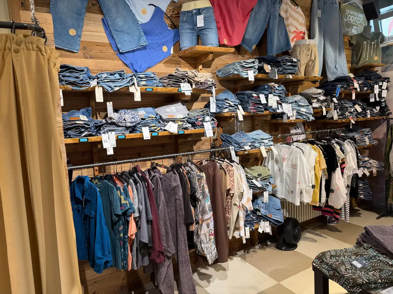 Denim-Regale mit gefalteten Jeans und Accessoires.